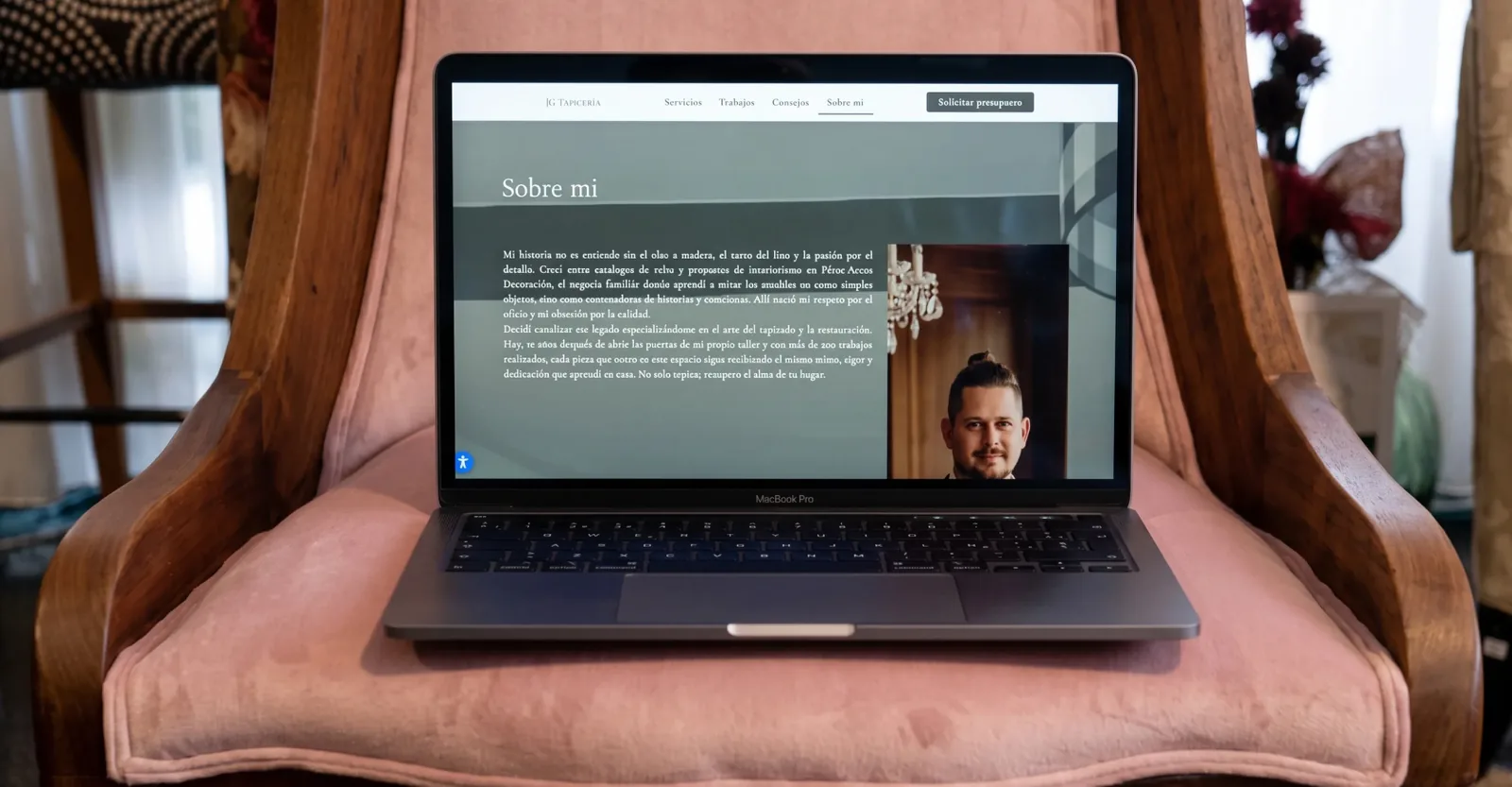 Portátil sobre un sillón mostrando la página «Sobre mí» del sitio